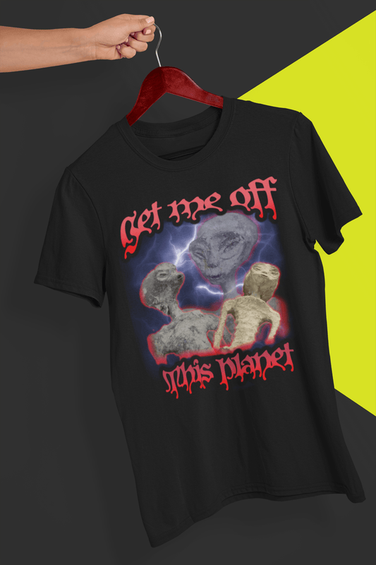 A black bootleg style t-shirt of 3 funny looking aliens written &quot;Get me off this planet&quot; in red bloody font; the tshirt is hung on a red hanger, held by a hand against a split black and yellow background.