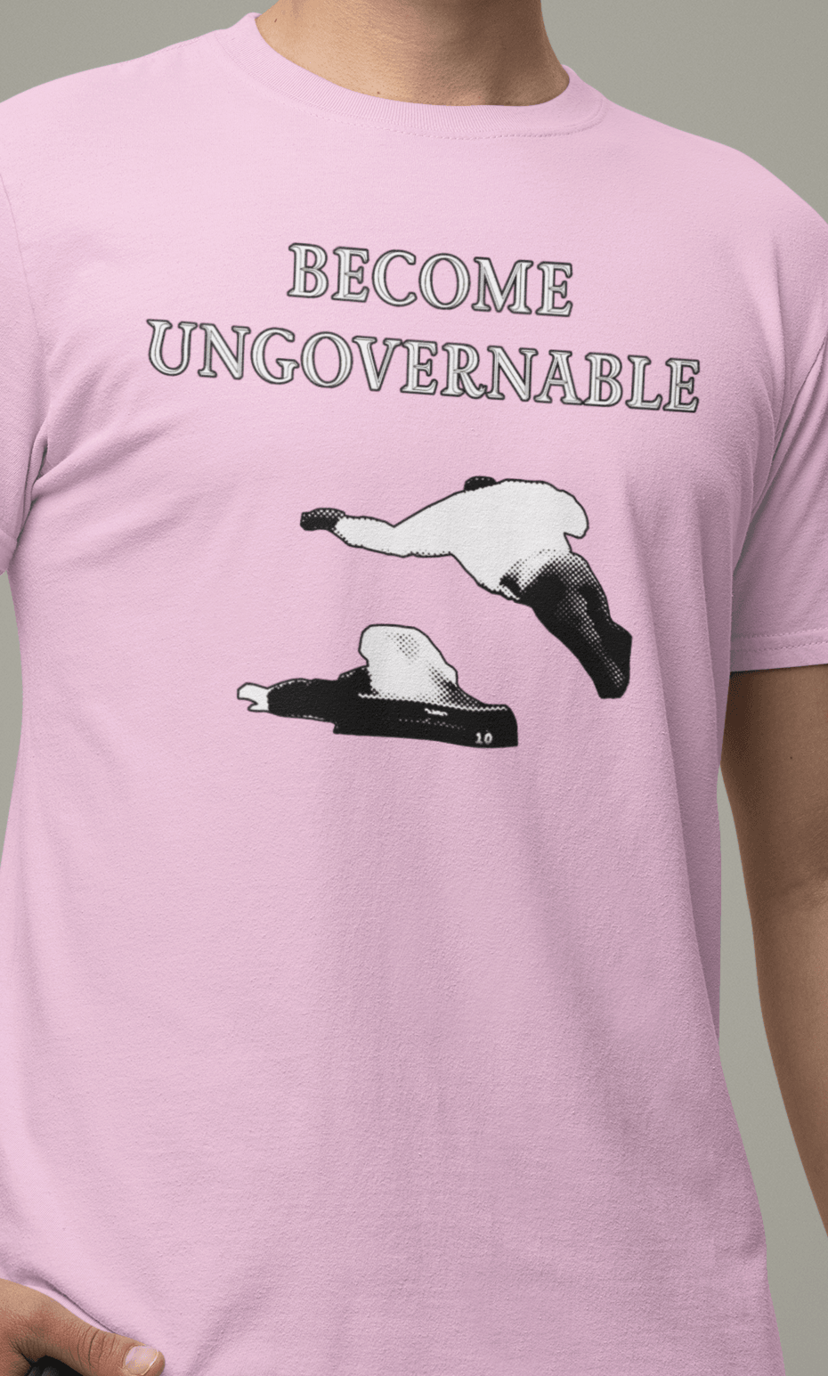 A man in a pink T-shirt with &quot;BECOME UNGOVERNABLE&quot; text and a white graphic of a leaping man onto a judge.