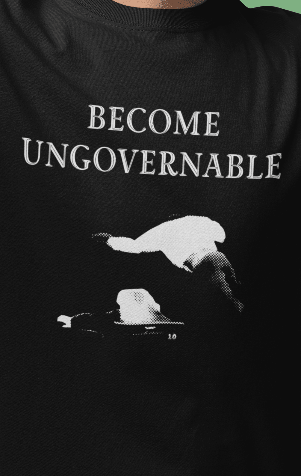 A man in a black T-shirt with &quot;BECOME UNGOVERNABLE&quot; text and a white graphic of a leaping man onto a judge.