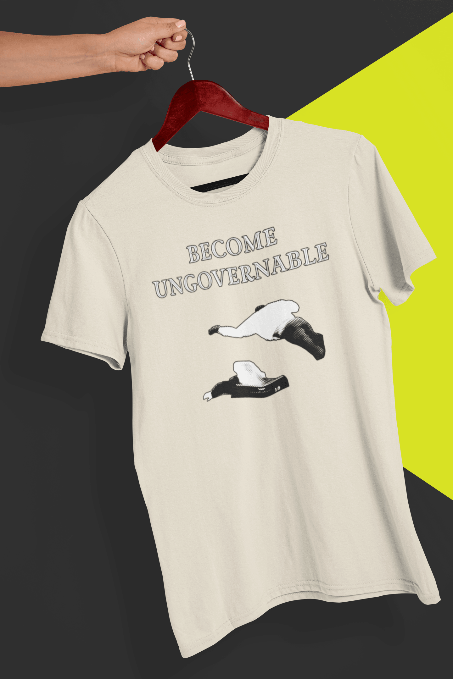 An off-white T-shirt with &quot;BECOME UNGOVERNABLE&quot; in black text and a white graphic of a leaping man onto a judge, held on a red hanger against a split black and yellow background.