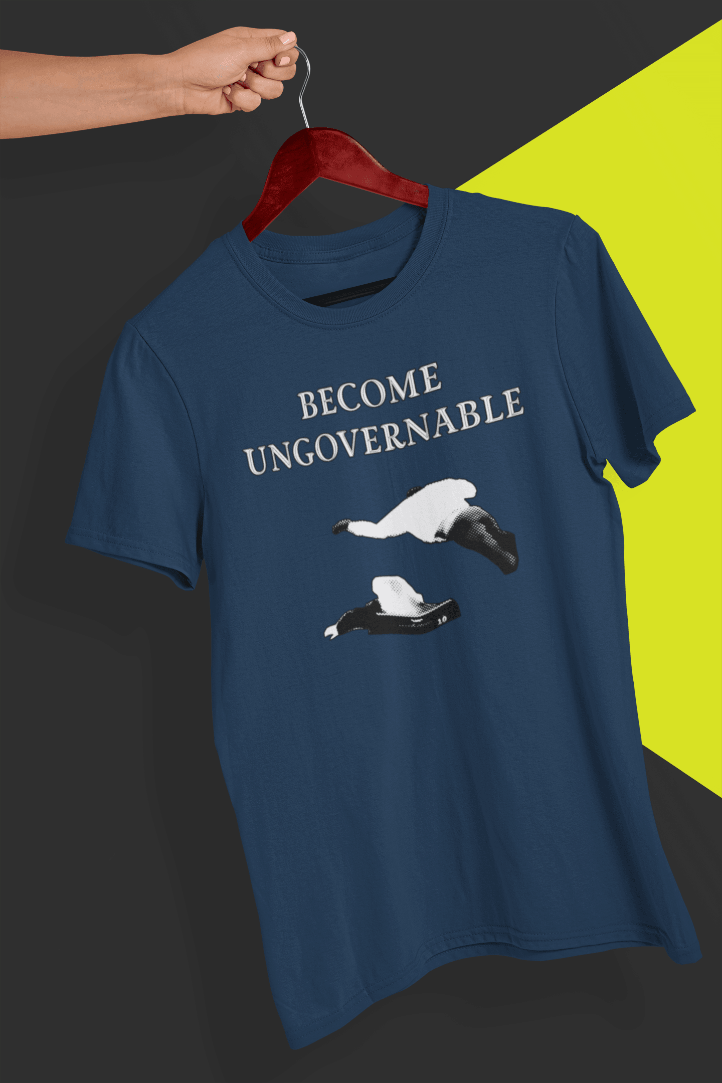 A navy blue T-shirt with &quot;BECOME UNGOVERNABLE&quot; in black text and a white graphic of a leaping man onto a judge, held on a red hanger against a split black and yellow background.