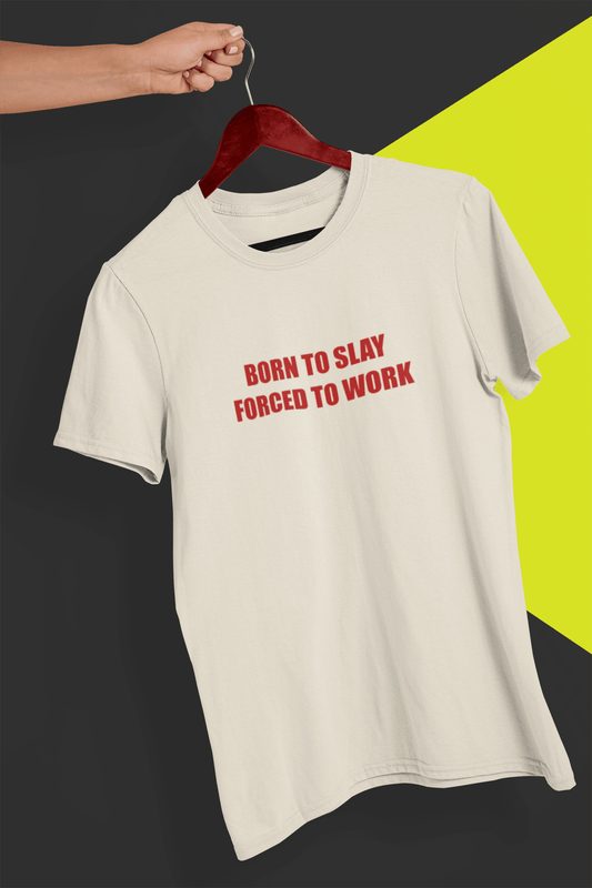 An off-white T-shirt that says &quot;Born to slay, forced to work&quot;, held by a hand against a split black and yellow background.