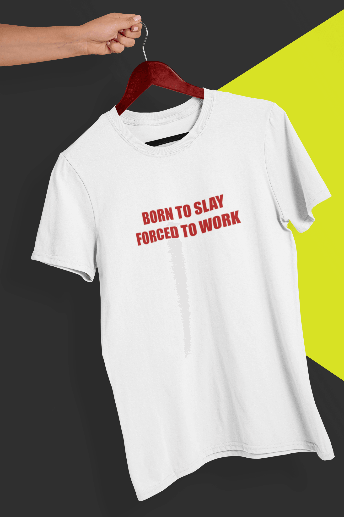 A white T-shirt that says &quot;Born to slay, forced to work&quot;, held by a hand against a split black and yellow background.