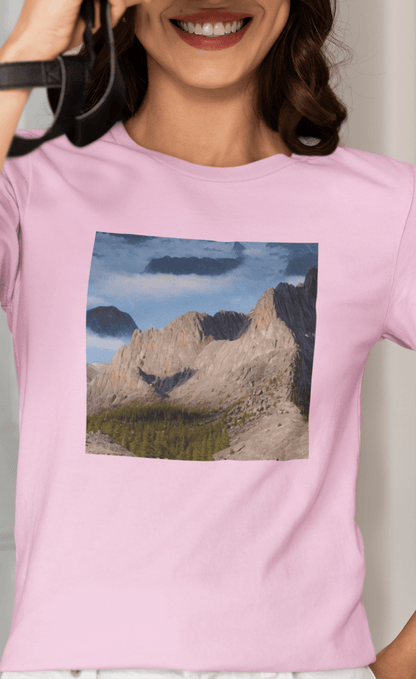 A woman wears a pink T-shirt featuring an AI generated landscape that looks like a cat taking a selfie staring at the camera