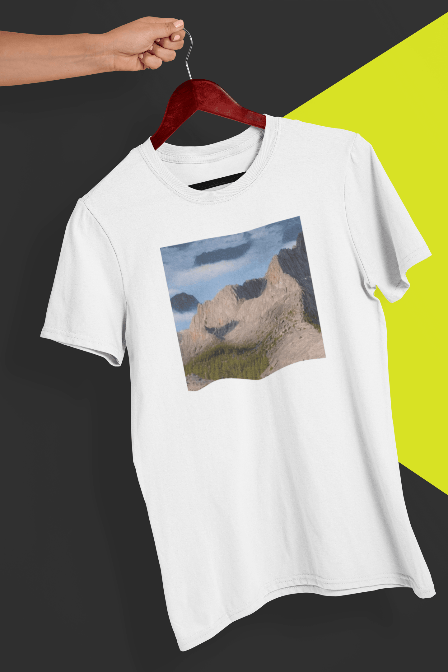 A white T-shirt featuring an AI generated landscape that looks like a cat taking a selfie staring at the camera, held by a hand against a split black and yellow background.