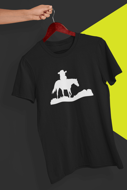 A black T-shirt with a silhouette of a pepe riding a horse in the middle., held by a hand against a split black and yellow background.