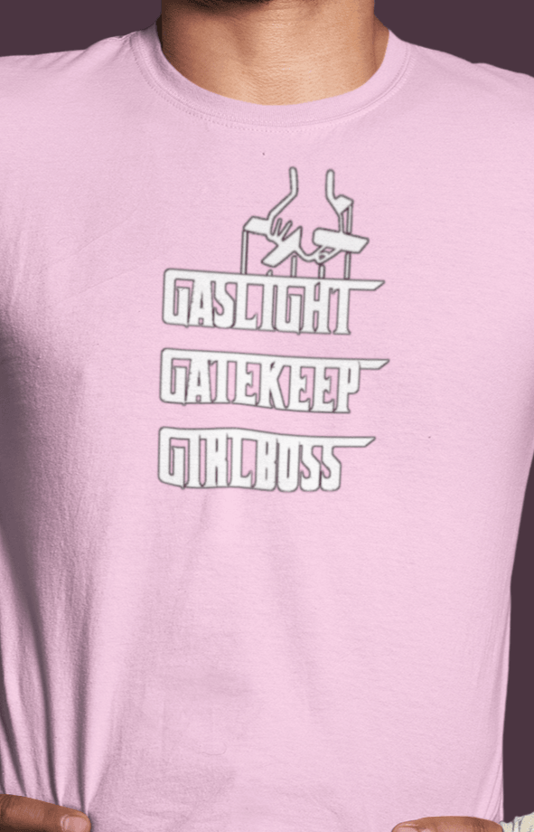 A man wears a pink T-shirt that says &quot;Gaslight, Gatekeep, Girlboss&quot;.