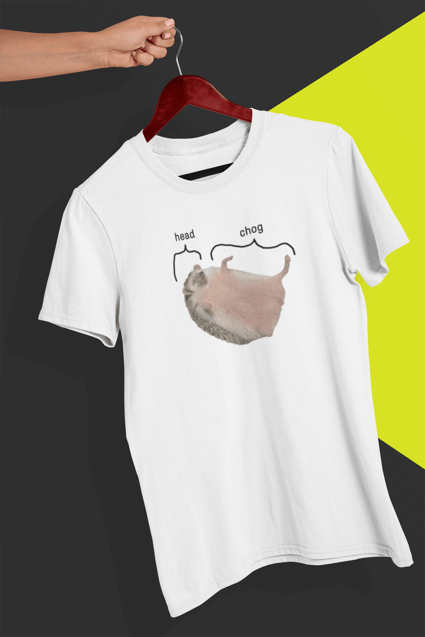 A white T-shirt featuring a cute hedgehog, which says &quot;head&quot; pointing at his head, and &quot;chog&quot; pointing at the rest of his body, is hung on a red hanger, held by a hand against a split black and yellow background.