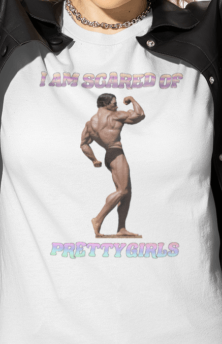 A woman wears a white T-shirt featuring the bodybuilder Arnold Schwarzenegger flexing, saying &quot;I am scared of pretty girls&quot;