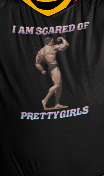 A man wears a black T-shirt featuring the bodybuilder Arnold Schwarzenegger flexing, saying &quot;I am scared of pretty girls&quot;