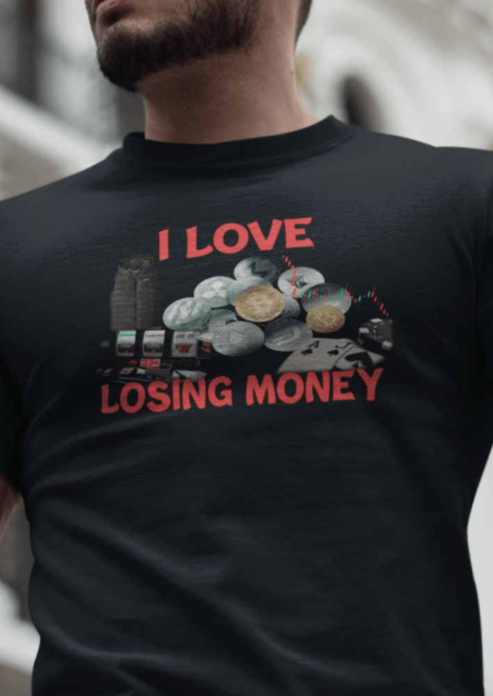 A man wears a black T-shirt with graphs and cryptos written &quot;I Live Losing Money&quot;.