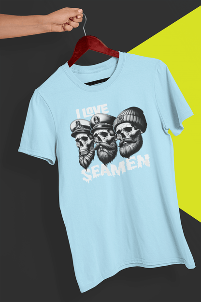 A light blue T-shirt with three men of the sea written &quot;I Love Seamen&quot;. is hung on a red hanger, held by a hand against a split black and yellow background.