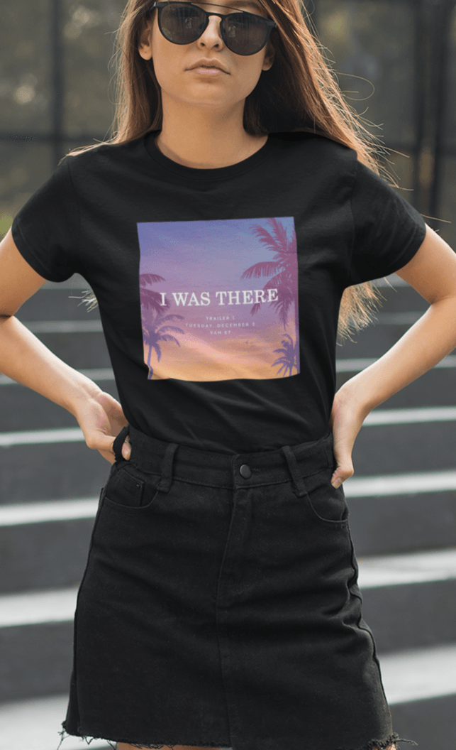 A woman wearing a black T-shirt with an aesthetic miami imagery written &quot;I WAS THERE, Trailer 1, Tuesday, December 5, 9AM ET&quot;