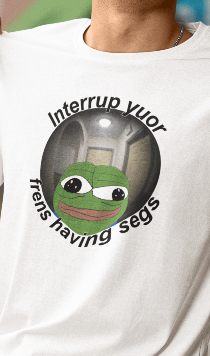 A man wears a white T-shirt featuring a peepo frog on the other side of a door peephole, saying &quot;Interrupt your friends having sex&quot; full of typos