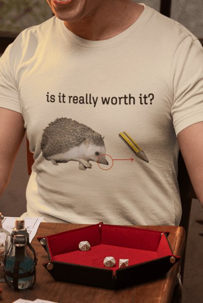 A man wears an off-white T-shirt featuring a cute hedgehog, showing the similarity between its nose and the tip of a pencil, saying &quot;is it really worth it?&quot;