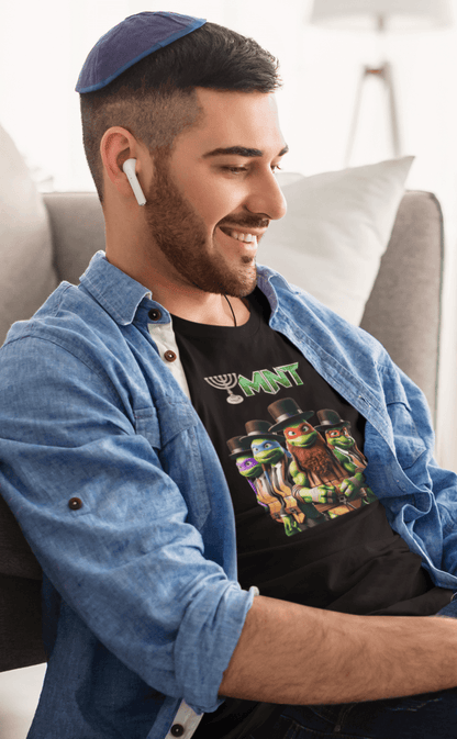 A man wears a black T-shirt featuring Teenage Mutant Ninja Turtles wearing hasidic attire, and text that says &quot;TMNT&quot; with the &quot;T&quot; stylized as a menorah