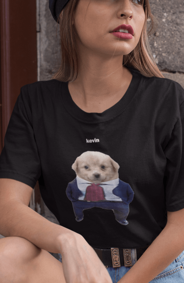 A woman wears a black T-shirt featuring a cute dog wearing a suit written &quot;kevin&quot; on top of him.