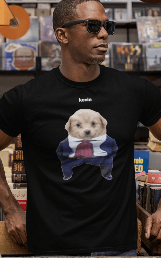 A man wears a black T-shirt featuring a cute dog wearing a suit written &quot;kevin&quot; on top of him.