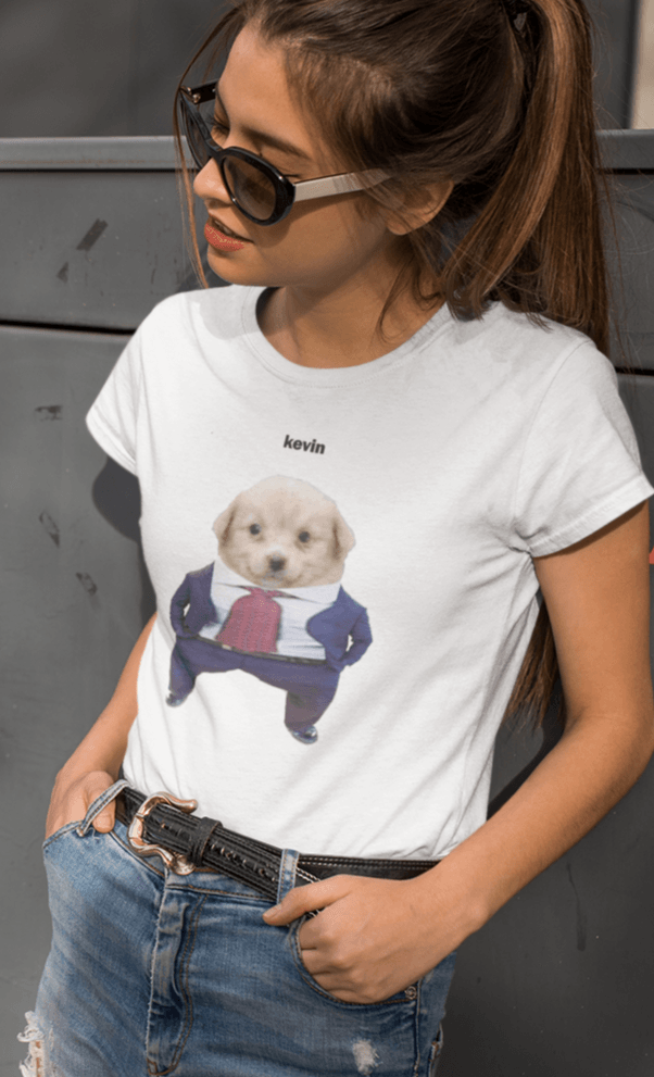 A woman wears a white T-shirt featuring a cute dog wearing a suit written &quot;kevin&quot; on top of him.