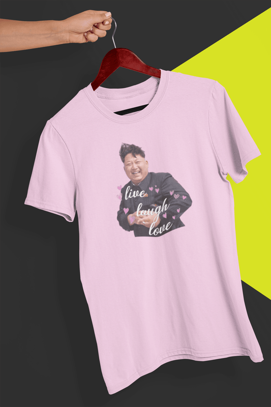 A pink T-shirt of kim jong un laughing saying &quot;Live Laugh Love&quot;, held by a hand against a split black and yellow background.