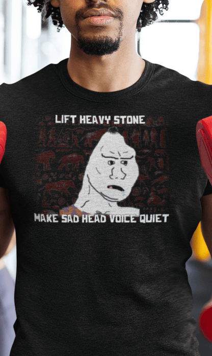 A man wears a black T-shirt featuring a neanderthal looking drawing, saying &quot;lift heavy stone make sad head voice quiet&quot;.