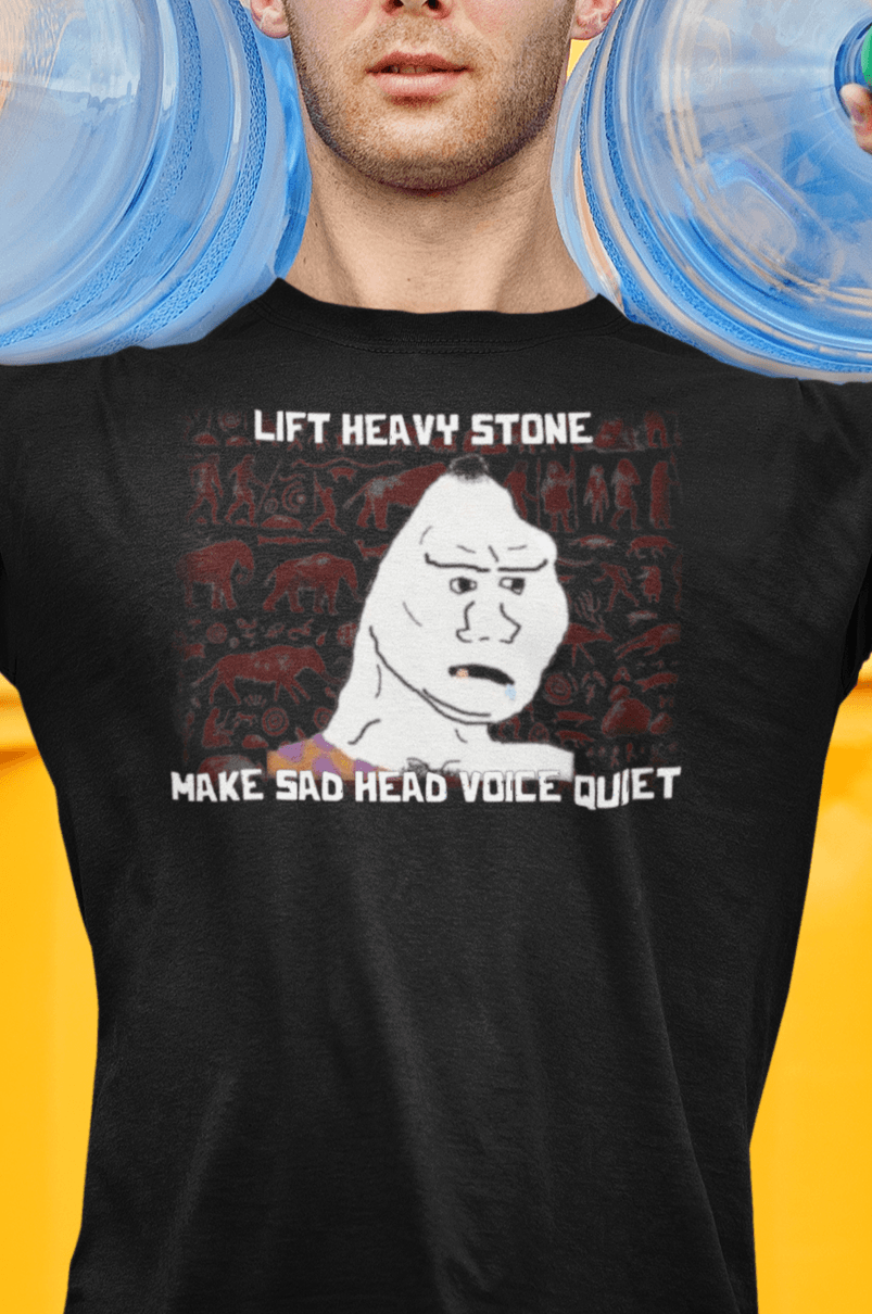 A man wears a black T-shirt featuring a neanderthal looking drawing, saying &quot;lift heavy stone make sad head voice quiet&quot;.