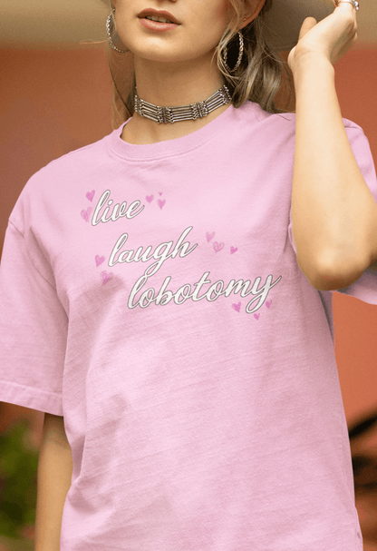 A woman wearing a pink T-shirt saying &quot;Live Laugh Lobotomy&quot;.