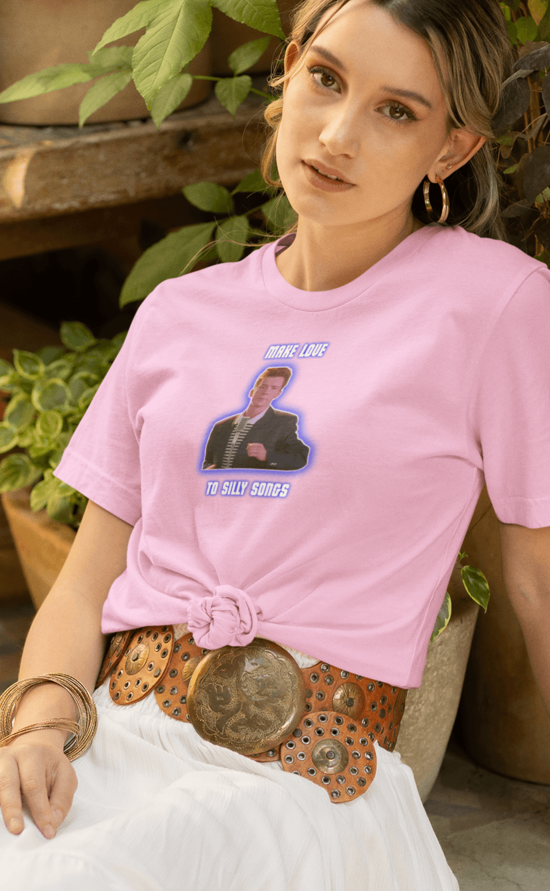 A woman wears a pink T-shirt with a depiction of Rick Astley that says &quot;Make Love To Silly Songs&quot;.