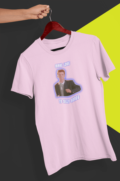 A pink T-shirt with a depiction of Rick Astley that says &quot;Make Love To Silly Songs&quot;, held by a hand against a split black and yellow background.