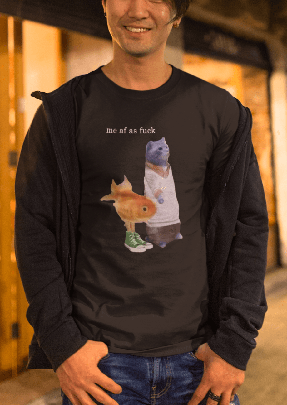 A person wears a black T-shirt featuring a cute cat and fish portraying Gumball and Darwin with &quot;me af as fuck&quot; written on top.