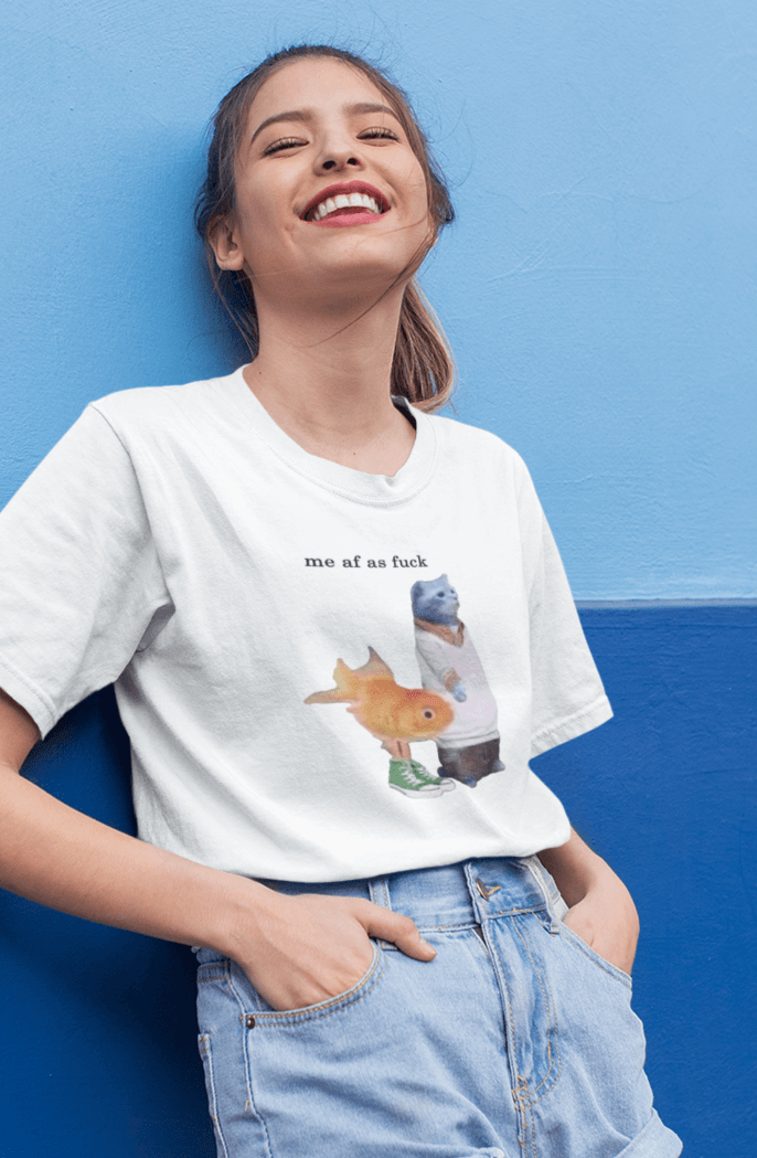 A woman wears a white T-shirt featuring a cute cat and fish portraying Gumball and Darwin with &quot;me af as fuck&quot; written on top.