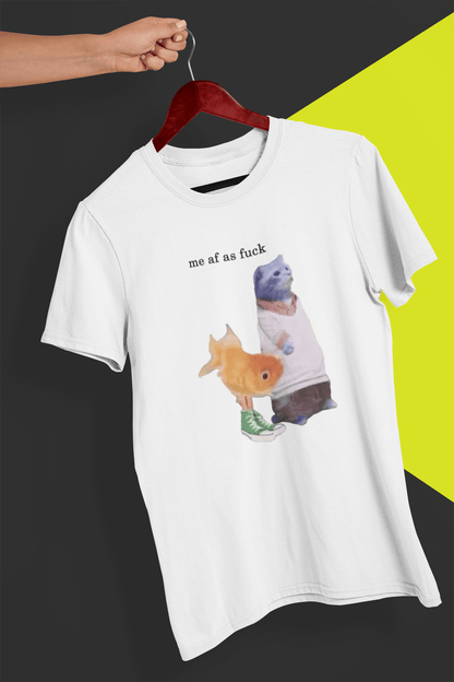 A white T-shirt with a cute cat and fish portraying Gumball and Darwin with &quot;me af as fuck&quot; written on top, is hung on a red hanger, held by a hand against a split black and yellow background.