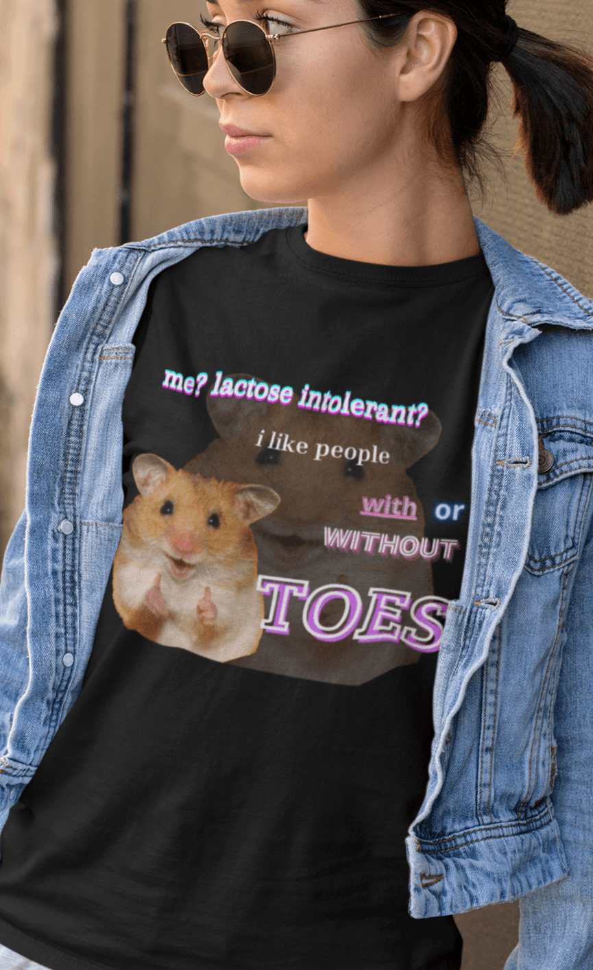 A woman wears a black T-shirt featuring a cute hamster doin a thumbs up written &quot;Me? Lactose intolerant? I like people with or without TOES&quot;