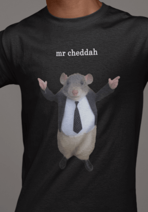 A man wears a black T-shirt featuring a cute rat wearing a suit written &quot;mr cheddah&quot; on top of him.