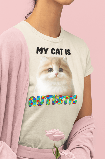 A woman wears an off-white T-shirt featuring a cute cat written &quot;My Cat is Autistic&quot; on top.