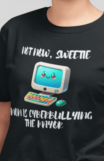 A woman wears a black T-shirt featuring a cute computer written &quot;Not now, sweetie, mom is cyberbullying the mayor&quot;.