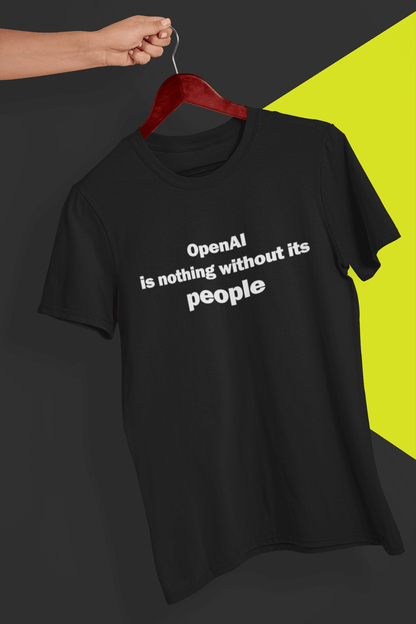 A black T-shirt written &quot;OpenAI is nothing without its people&quot;, is hung on a red hanger, held by a hand against a split black and yellow background.