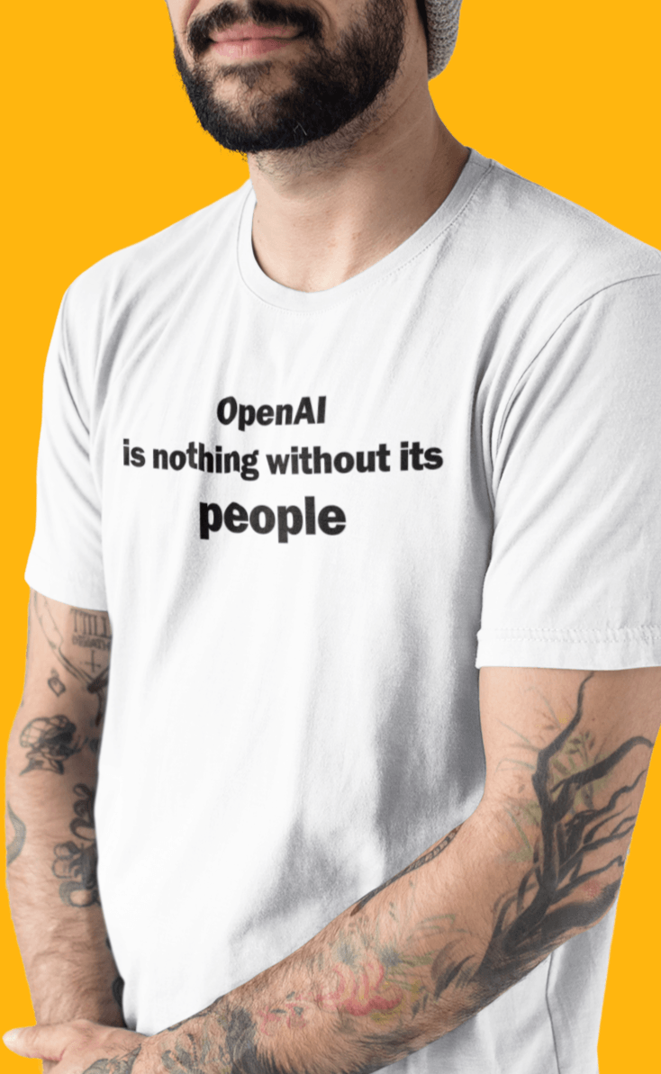 A person wears a white T-shirt written &quot;OpenAI is nothing without its people&quot;.