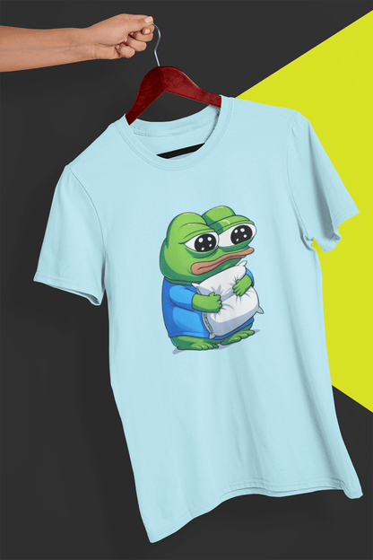 A light blue T-shirt with a cute apu apustaja pepe in the middle hugging a pillow, held by a hand against a split black and yellow background.