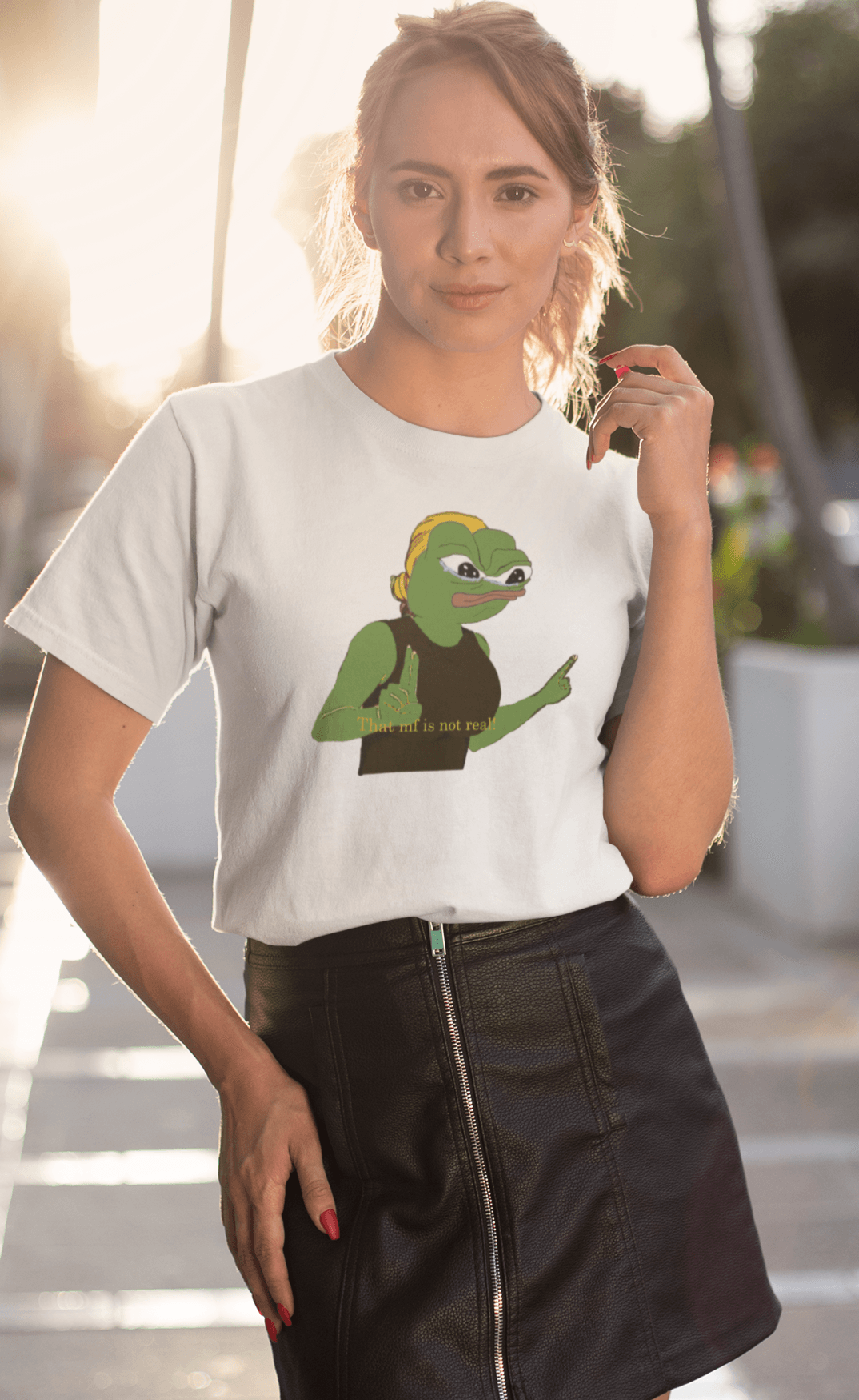 A woman wears a white T-shirt featuring a cute apu apustaja pepe in the middle pointing and written &quot;That MF isn&#39;t real!&quot;.