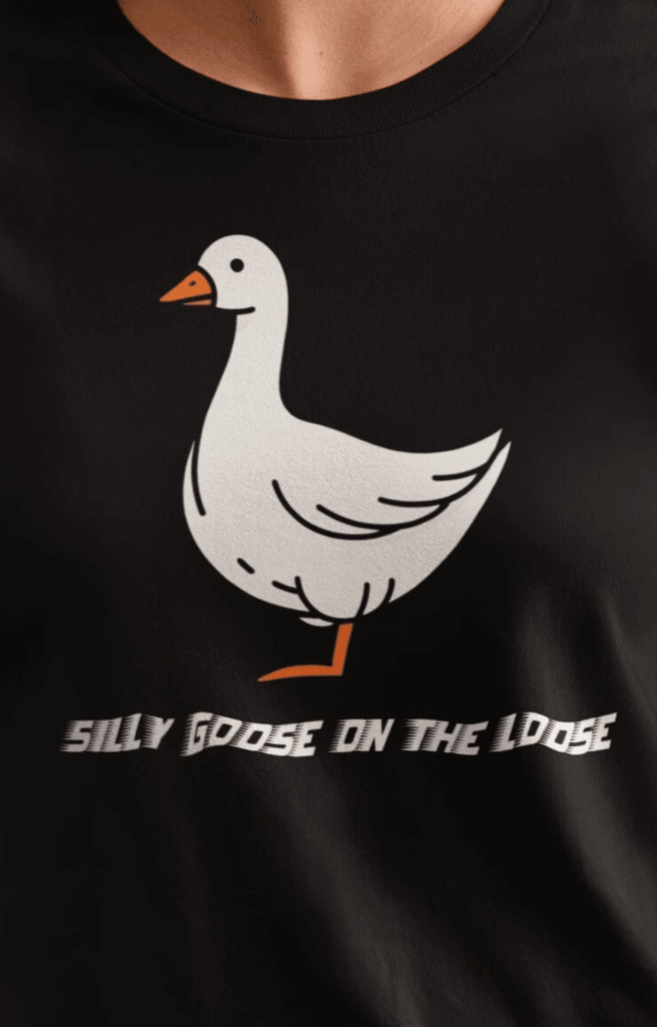 A woman wears a black T-shirt featuring a cute mischievous goose in the middle, saying &quot;Silly goose on the loose&quot;.