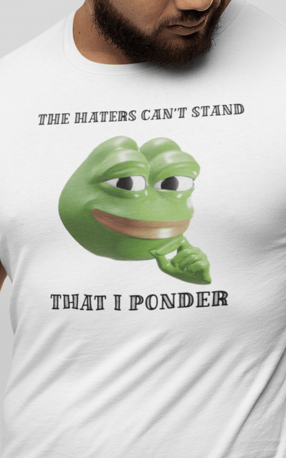 A man wears a white T-shirt featuring a funny 3d smug pepe in the middle, saying &quot;The haters cant&#39;s stand that I ponder&quot;.