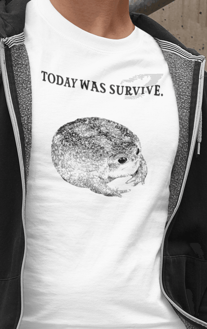 A man wears a white T-shirt featuring a cute toad, saying &quot;today was survive.&quot;