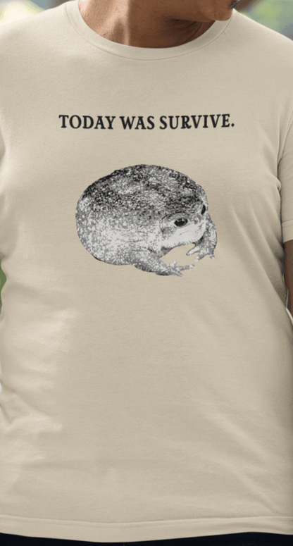 A man wears an off-white T-shirt featuring a cute toad, saying &quot;today was survive.&quot;