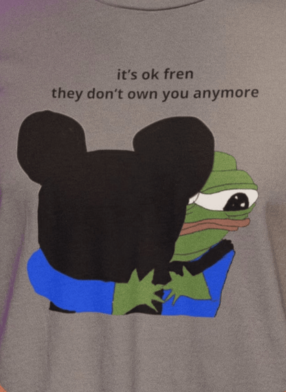 A man wears a gray T-shirt featuring Mickey Mouse hugging a cute Apu in the middle, saying &quot;it&#39;s ok fren, they don&#39;t own you anymore&quot;.