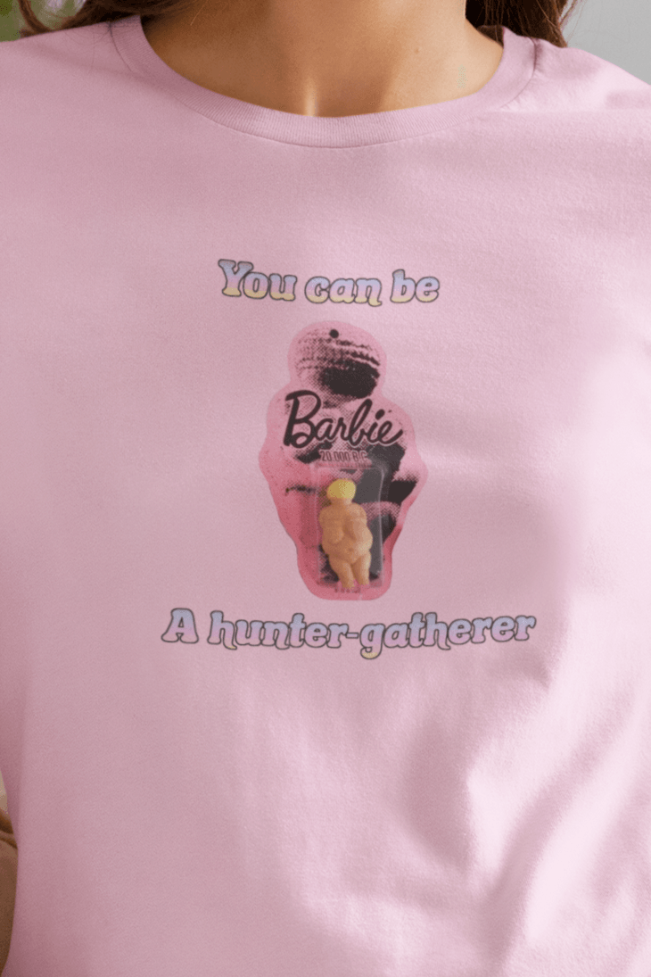 A woman wears a pink T-shirt featuring the venus impudique that says &quot;Barbie You can be a hunter-gatherer&quot;.