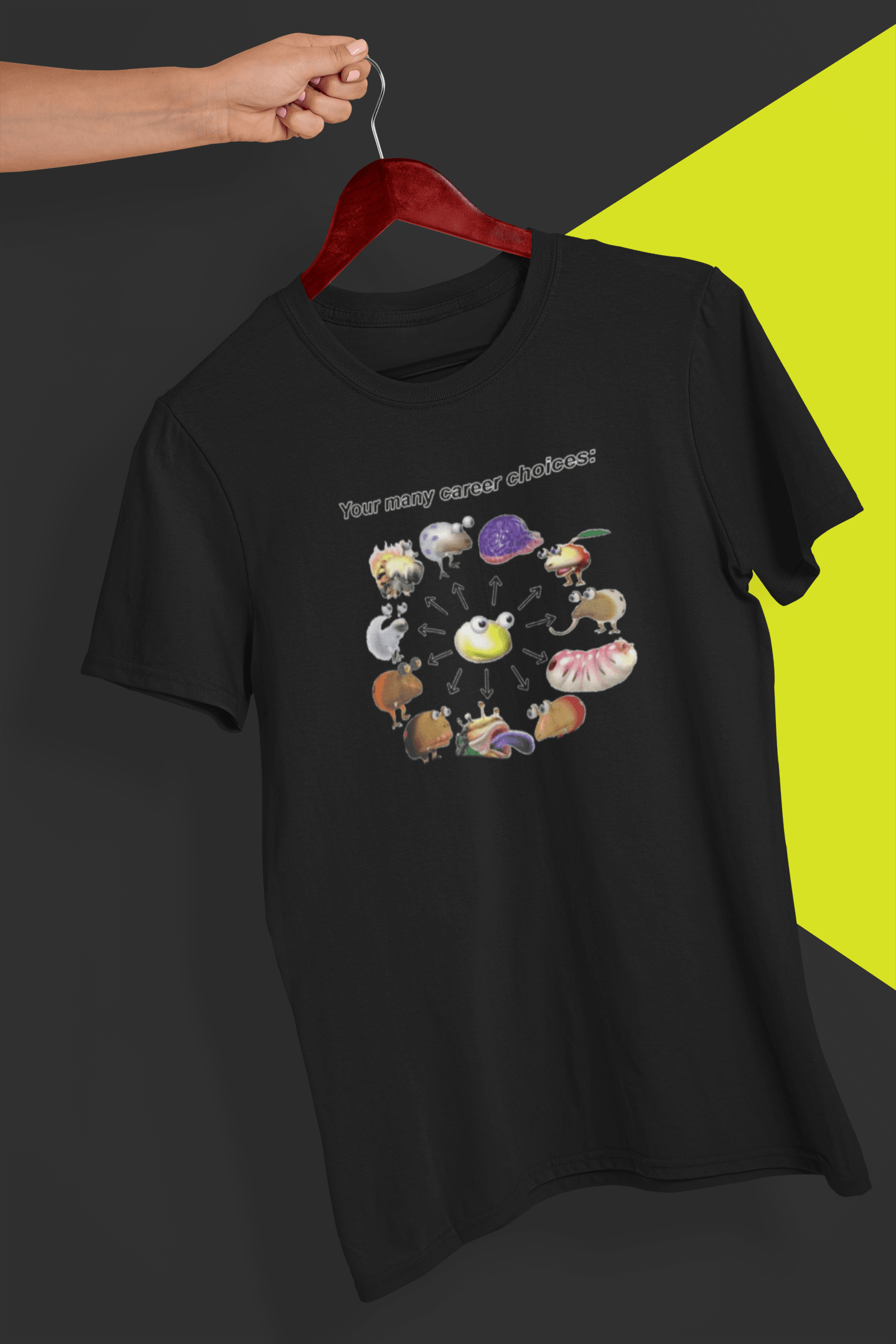 A black T-shirt saying &quot;Your many career choices:&quot;, featuring a bunch of cute weird monsters, held by a hand against a split black and yellow background.